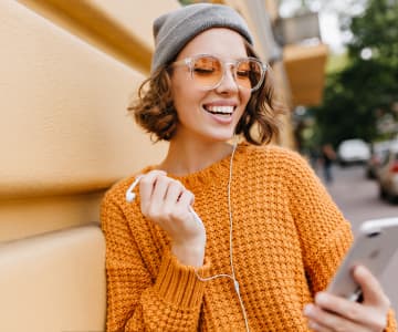 woman in yellow pullover with headphones